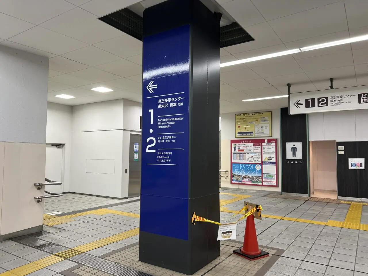駅改札内の柱をオレンジのコーンとテープで囲っている様子