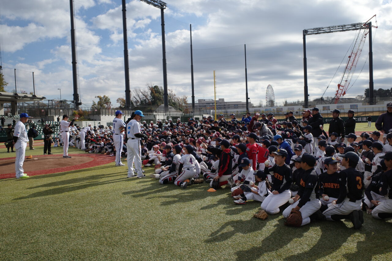 ボールの持ち方をコーチから教わる子どもたち